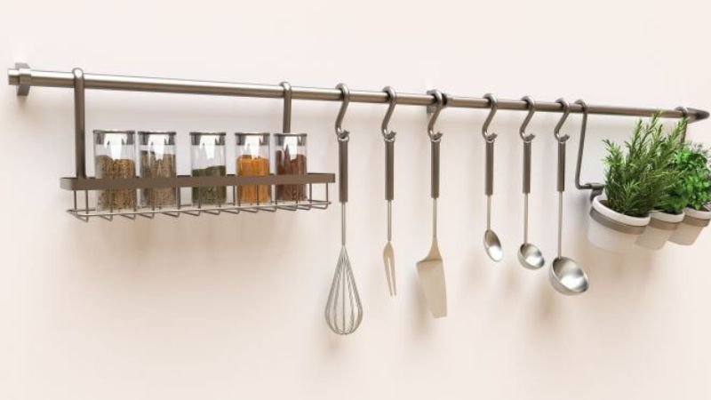 Trilho com ganchos para utensílios e temperos em cozinha organizada